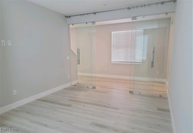 spare room with wood finished floors and baseboards