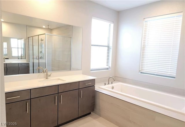 full bathroom with a stall shower, a garden tub, and vanity