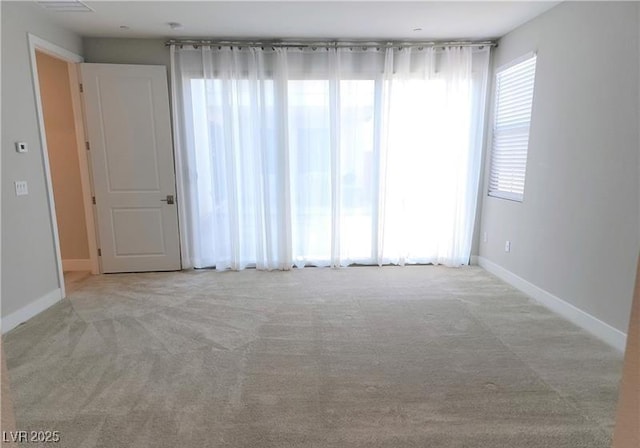 spare room featuring carpet floors and baseboards