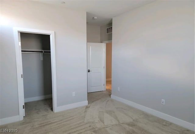 unfurnished bedroom with carpet, a closet, and baseboards