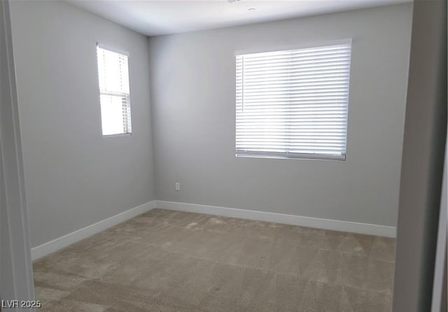 spare room featuring carpet flooring and baseboards