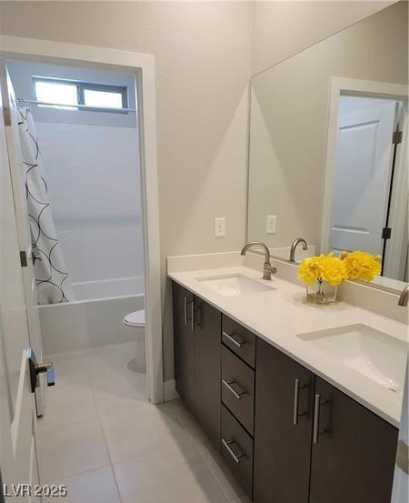 full bathroom featuring toilet, double vanity, shower / bath combo, and tile patterned floors