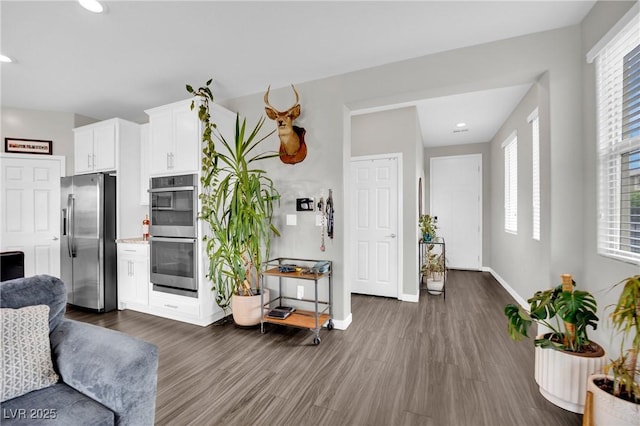 living area featuring dark wood-style flooring, baseboards, and recessed lighting