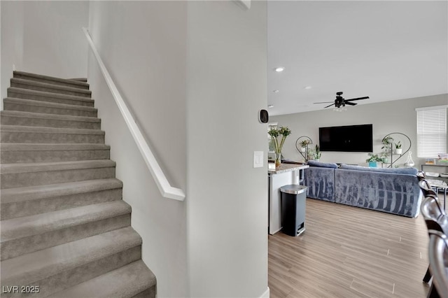 stairway featuring ceiling fan, recessed lighting, and wood finished floors