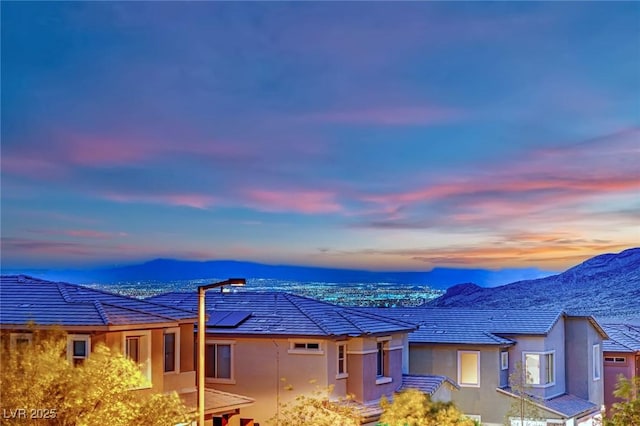 exterior space featuring stucco siding, a mountain view, and solar panels