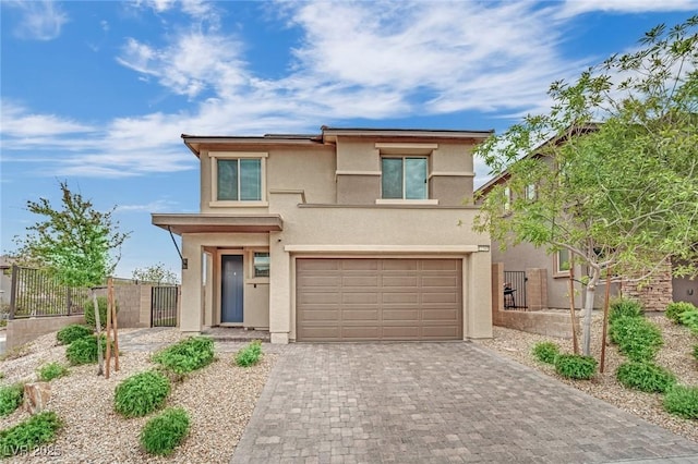 view of front of property with stucco siding, an attached garage, decorative driveway, and fence