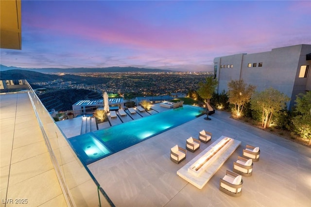 pool at dusk featuring a community pool