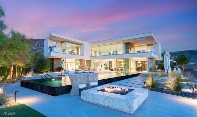 13 Rockstream Dr, Henderson, NV 89012 - rear view of house with an outdoor fire pit, a patio area, and a balcony