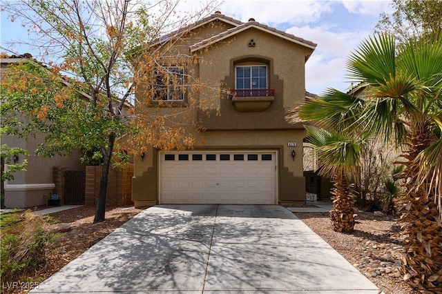 view of front of property with driveway, stucco siding, a garage, and a tile roof