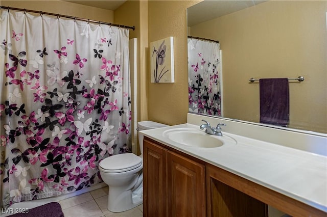 bathroom with toilet, tile patterned flooring, vanity, curtained shower, and a textured wall