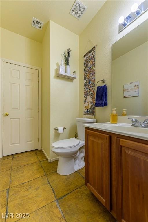 half bath featuring toilet, tile patterned floors, and vanity