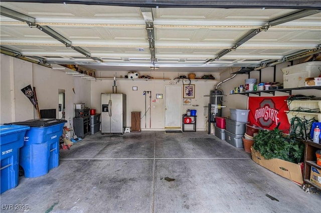 garage featuring stainless steel refrigerator with ice dispenser and water heater