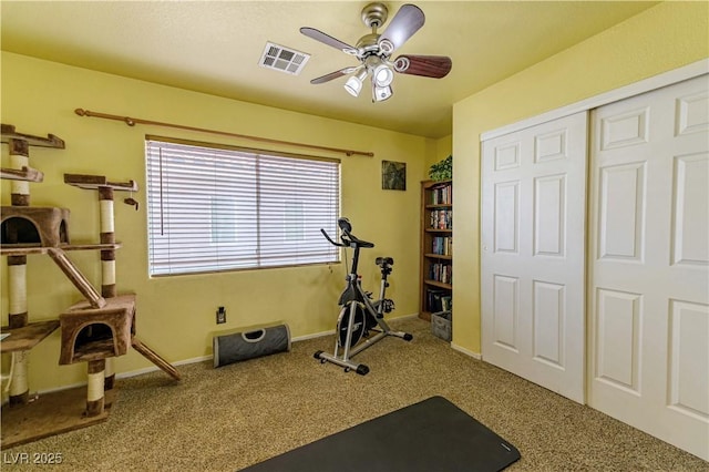 workout area featuring a ceiling fan, carpet, and baseboards