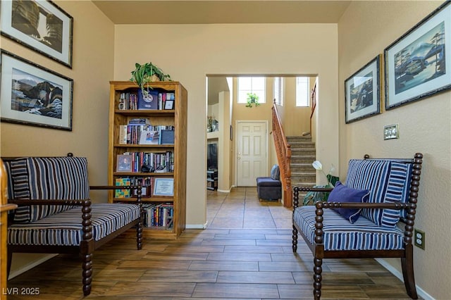 sitting room with stairway, wood tiled floors, and baseboards