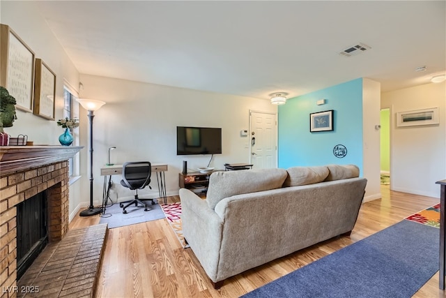 5576 W Rochelle Ave Unit 27C, Las Vegas, NV 89103 - living area featuring a brick fireplace, light wood-type flooring, and baseboards