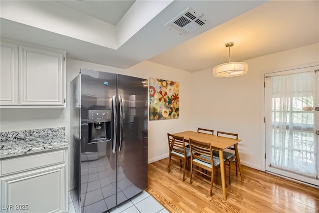 5576 W Rochelle Ave Unit 27C, Las Vegas, NV 89103 - kitchen featuring stainless steel fridge with ice dispenser, white cabinetry, light wood-type flooring, pendant lighting, and baseboards