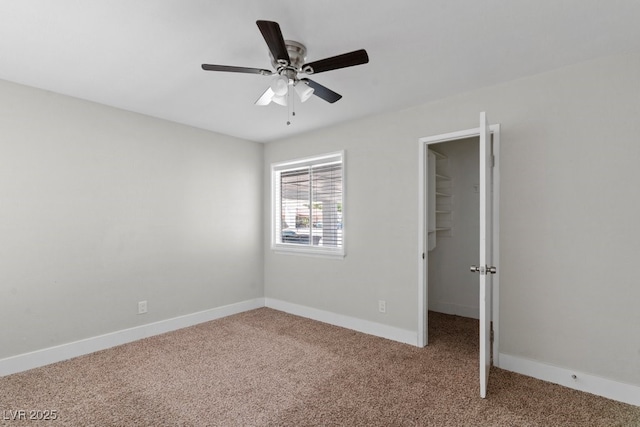 unfurnished bedroom featuring carpet, a spacious closet, baseboards, and a closet