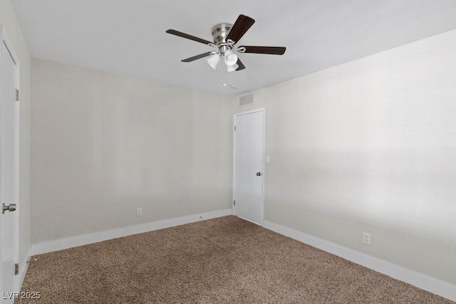 carpeted spare room with a ceiling fan and baseboards