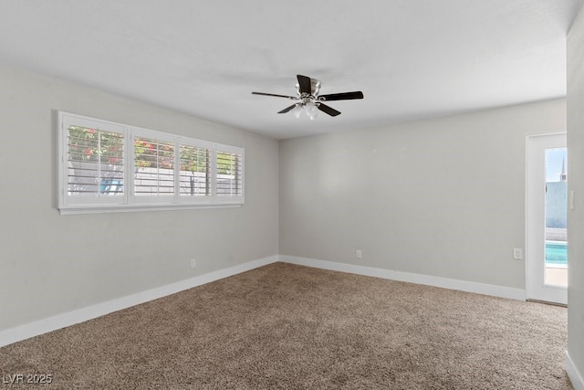 empty room with carpet floors, a ceiling fan, and baseboards