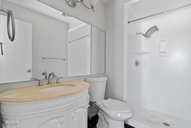 bathroom featuring a stall shower, toilet, and vanity