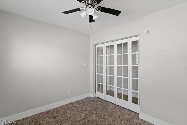 carpeted empty room featuring ceiling fan and baseboards
