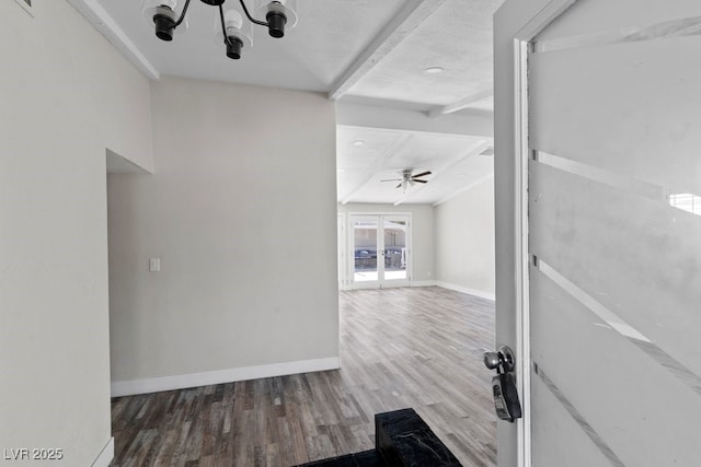 hallway featuring wood finished floors, baseboards, beamed ceiling, french doors, and a chandelier