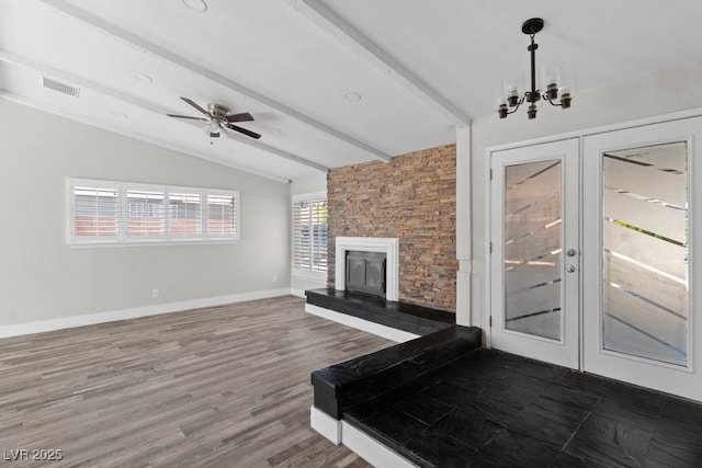living area with french doors, a fireplace, a chandelier, and ceiling fan