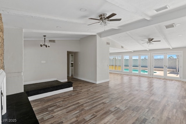 unfurnished living room with baseboards, wood finished floors, ceiling fan, and a chandelier