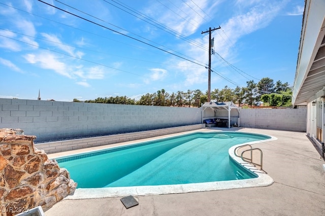 view of swimming pool with a fenced backyard and a patio area