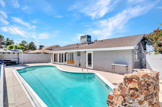 view of swimming pool with a fenced backyard, a patio, and central AC