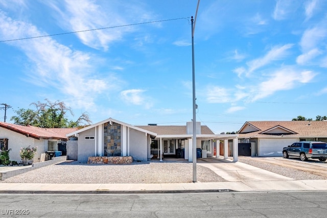 view of front of property featuring concrete driveway, stucco siding, and stone siding