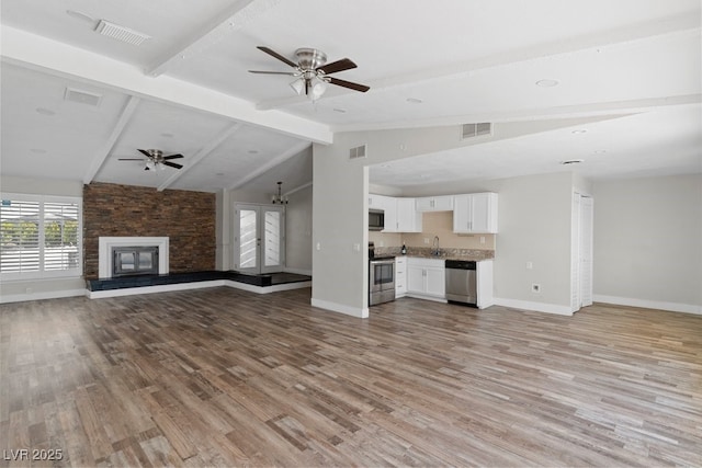 unfurnished living room featuring ceiling fan, light wood finished floors, baseboards, and a fireplace