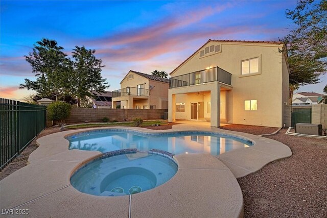 1221 Diamond Valley St, Henderson, NV 89052 - pool at dusk featuring a fenced backyard, a pool with connected hot tub, and a patio area