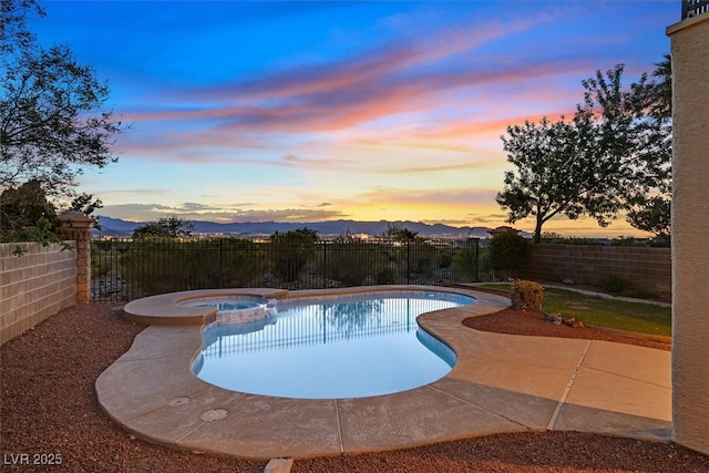 1221 Diamond Valley St, Henderson, NV 89052 - pool at dusk featuring a fenced backyard, a patio area, a pool with connected hot tub, and a mountain view