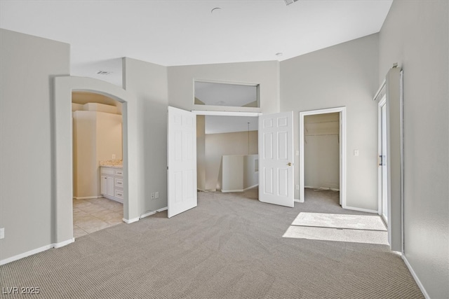 1221 Diamond Valley St, Henderson, NV 89052 - unfurnished bedroom with light carpet, baseboards, arched walkways, a closet, and high vaulted ceiling