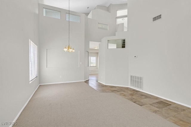 1221 Diamond Valley St, Henderson, NV 89052 - unfurnished living room with a chandelier, a high ceiling, baseboards, carpet floors, and tile patterned floors