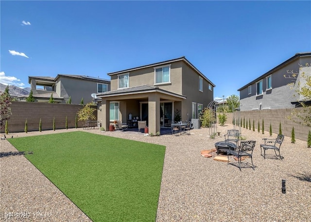 12429 Alpenglow Ct, Las Vegas, NV 89138 - rear view of house with an outdoor fire pit, stucco siding, a fenced backyard, and a patio