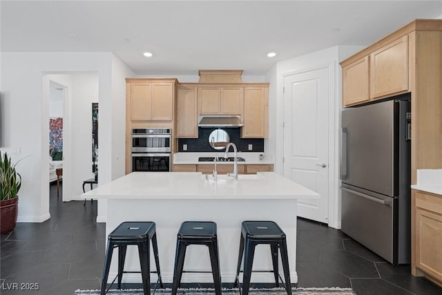 12429 Alpenglow Ct, Las Vegas, NV 89138 - kitchen with appliances with stainless steel finishes, light brown cabinetry, range hood, a kitchen breakfast bar, and light countertops