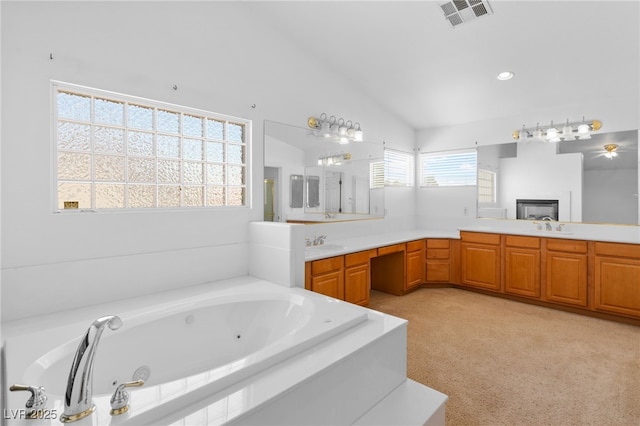 5396 Valley Wells Way, Las Vegas, NV 89113 - bathroom with vaulted ceiling, a tub with jets, a glass covered fireplace, and vanity