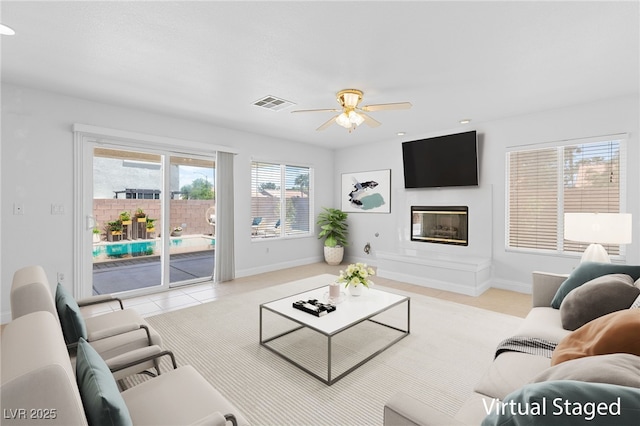 5396 Valley Wells Way, Las Vegas, NV 89113 - living room featuring tile patterned flooring, a glass covered fireplace, a ceiling fan, and baseboards
