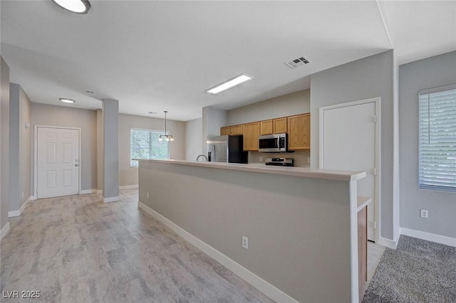 701 Peachy Canyon Cir Unit 201, Las Vegas, NV 89144 - kitchen featuring appliances with stainless steel finishes, baseboards, decorative light fixtures, light countertops, and an island with sink