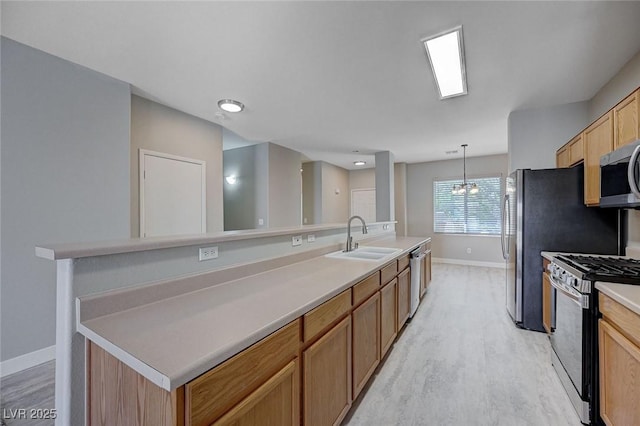 701 Peachy Canyon Cir Unit 201, Las Vegas, NV 89144 - kitchen with stainless steel appliances, a sink, light wood-type flooring, and baseboards