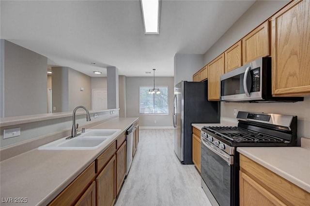 701 Peachy Canyon Cir Unit 201, Las Vegas, NV 89144 - kitchen with appliances with stainless steel finishes, a sink, baseboards, light wood-style floors, and a chandelier