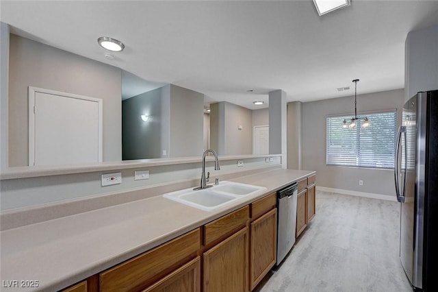 701 Peachy Canyon Cir Unit 201, Las Vegas, NV 89144 - kitchen with a sink, stainless steel appliances, brown cabinetry, baseboards, and light countertops