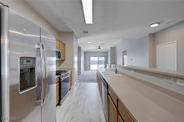 701 Peachy Canyon Cir Unit 201, Las Vegas, NV 89144 - kitchen with appliances with stainless steel finishes, a sink, light wood finished floors, ceiling fan, and brown cabinets