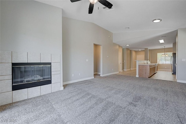 701 Peachy Canyon Cir Unit 201, Las Vegas, NV 89144 - unfurnished living room with a ceiling fan, a fireplace, light colored carpet, baseboards, and vaulted ceiling