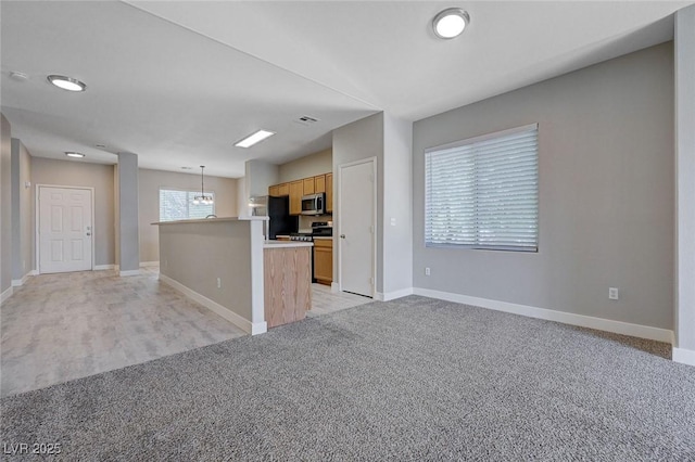 701 Peachy Canyon Cir Unit 201, Las Vegas, NV 89144 - kitchen featuring stainless steel microwave, light carpet, baseboards, and hanging light fixtures
