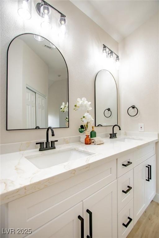 bathroom with double vanity and wood finished floors