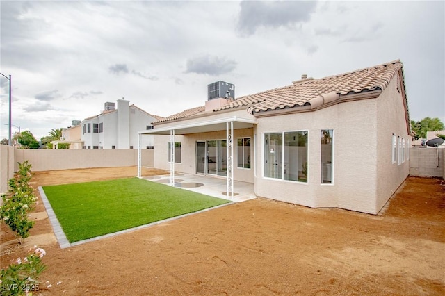 rear view of house with a tile roof, a patio area, and stucco siding