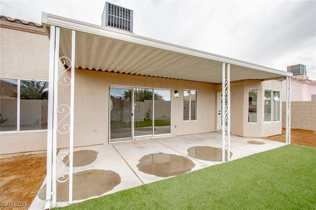 rear view of house featuring cooling unit, stucco siding, and a patio